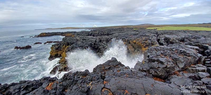 Rough ocean waves crash against the lava shore near Grindavik.